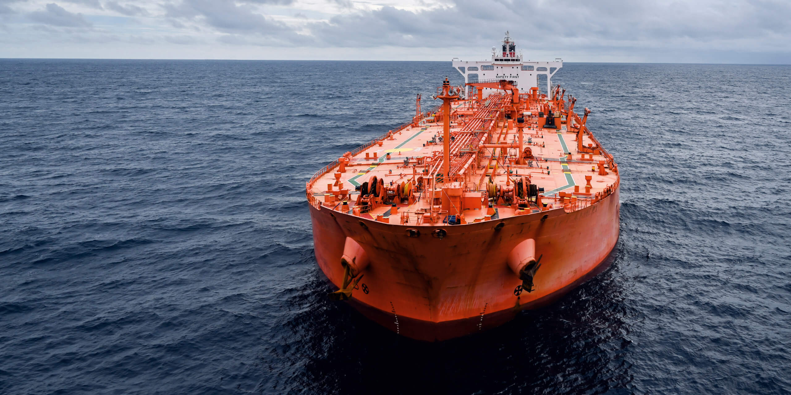 A ship in the sea, the top of the container is painted vermillion.